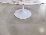 a marble table with a white pedestal on the floor