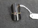 une bague posée sur un objet noir muni d'une étiquette de prix