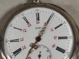 a silver pocket watch with roman numerals on it
