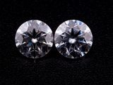une paire de diamants de taille ronde sur un fond noir
