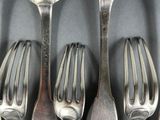 six forks and spoons are lined up on a gray surface