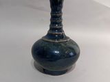 un vase bleu posé sur une table blanche