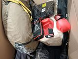 a cardboard box filled with items that include a backpack, gloves, gloves, and other items