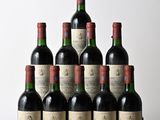 six bouteilles de vin sont posées sur une table en bois devant un mur blanc