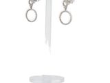 pair of silver earrings on a stand on a white background