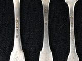 four forks are sitting next to each other on a black surface