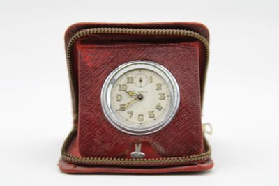 a small clock sitting inside of a case on a white surface