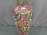 un vase coloré posé sur une surface grise