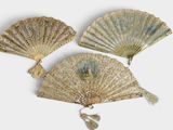 Trois éventails chinois anciens sont exposés sur un fond blanc