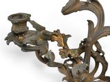 a candle holder that has flowers and leaves on it