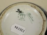 a close up of a vase with a tag on it