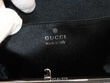 someone is holding a black purse with a white glove on it