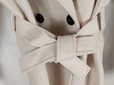 un gros plan sur un manteau orné d'un nœud