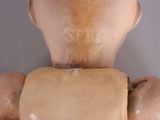 a close up of a doll ' s head with a piece of paper on it