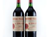 two bottles of red wine sitting next to each other on a white surface
