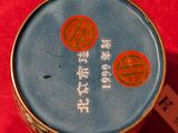 a small blue container with a red lid on a red surface