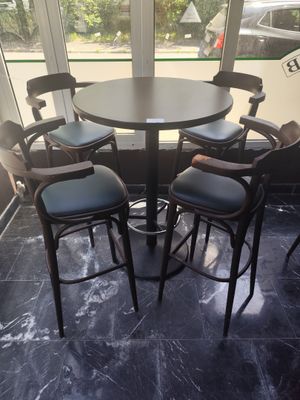 une table entourée de quatre chaises dans une pièce