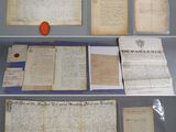 some old papers are on display on a shelf in a glass case