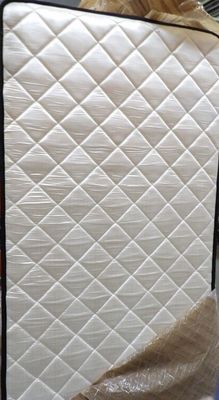 a mattress that has been wrapped up and is sitting on the floor