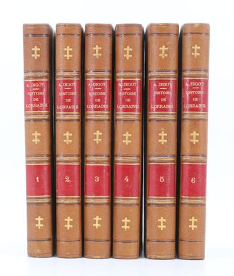 six vieux livres sont alignés sur une surface blanche