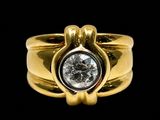 une image d'une bague en or avec un diamant au centre