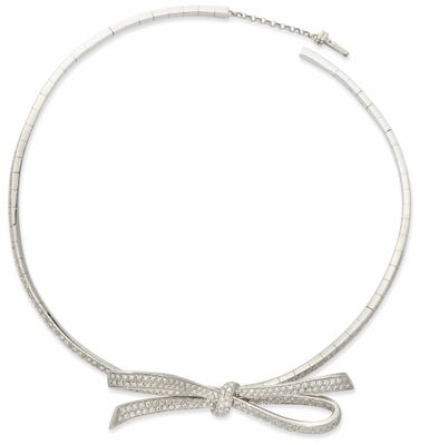 un gros plan d'un collier orné d'un nœud sur fond blanc