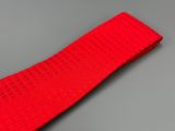 La cravate rouge est posée sur une surface grise.