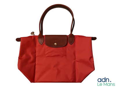 a red bag with brown handles on a white background