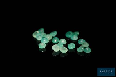 a close up of a group of green gems on a black surface