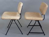 pair of mid - century chairs with upholstered backrests and metal legs