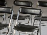 four black chairs sitting in a row on the floor