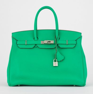 un sac à main en cuir vert muni d'un cadenas sur la poignée