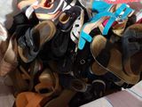 many pairs of shoes in a basket on a bed