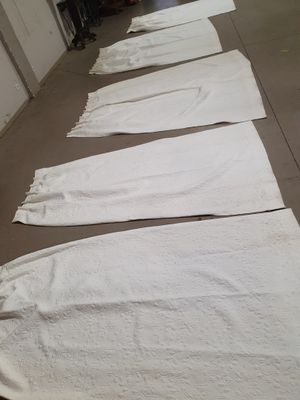 several white towels are lined up on the floor in a row