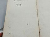 someone is holding an old book with writing on it in their hand