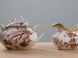 two small vases sitting on a table next to each other