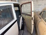 two old cars parked next to each other in a garage