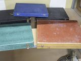 quatre valises posées sur une table, avec une horloge en arrière-plan