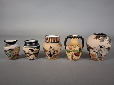 cinq vases aux motifs variés posés sur une table