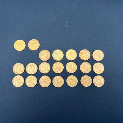 quelques pièces d'or sont disposées en rangée sur une surface bleue