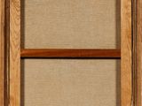 an old wooden window frame with a brown cloth covering it