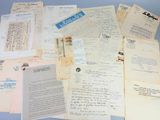 many old letters and papers are piled together on a blue surface