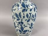 a blue and white vase sitting on a table