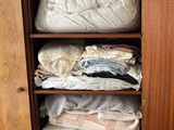 a wooden cabinet with a lot of clothes in it