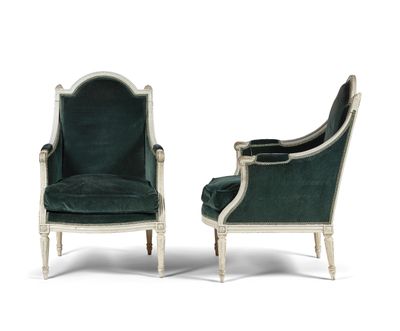 a pair of green velvet chairs with white trim and wood legs