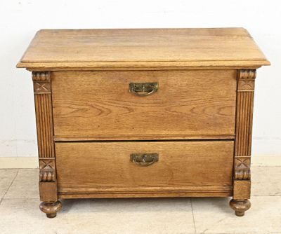 une vieille commode en bois surmontée de deux tiroirs