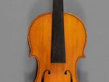 an old violin with a wooden back and bow on a gray background