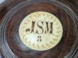 a close up of a wooden bowl with a monogram on it