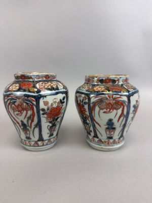 pair of chinese vases with floral designs on them on a white surface