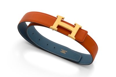 une ceinture Hermès avec une boucle dorée sur fond blanc